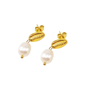 Détail de boucles d'oreilles coquillage doré avec perles polies et textures marines