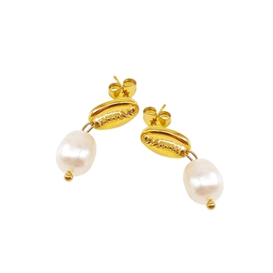 Détail de boucles d'oreilles coquillage doré avec perles d'eau douce sur fond blanc