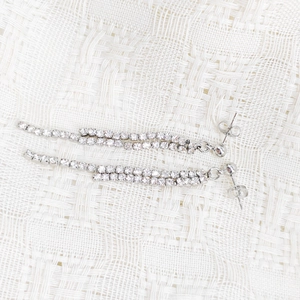 Detailed macro view of silver tassel earrings with double rows of sparkling cubic zirconia