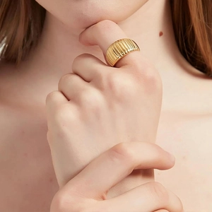 Macro view of wide gold plated stainless steel ring with elegant croissant texture