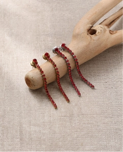 Gros plan de boucles d'oreilles à pampilles en strass rouges avec finitions or et argent