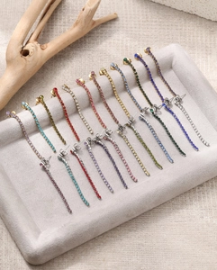 Gros plan de boucles d'oreilles à pampilles en zircon coloré sur un plateau gris
