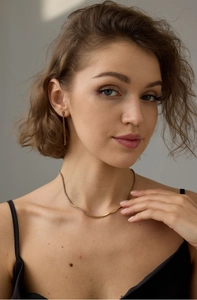 Gros plan d'un collier doré et de boucles d'oreilles en zircon violet sur un modèle
