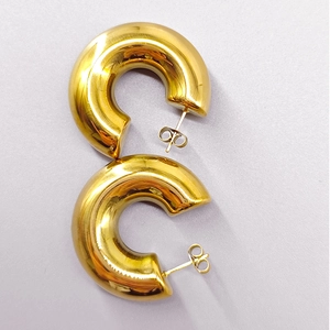 Macro view of chunky 18K gold-plated stainless steel C-shaped hoop earrings