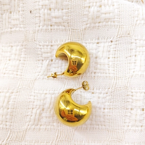 Polished 18K gold-plated C-shape drop earrings with mirror finish on white fabric