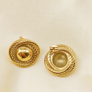 Macro shot of vintage gold spiral twisted metal stud earrings with smooth center spheres