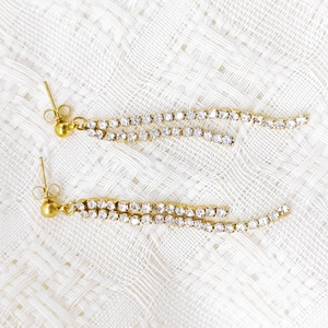 Close-up of elegant gold tassel earrings with double rows of sparkling white zircons