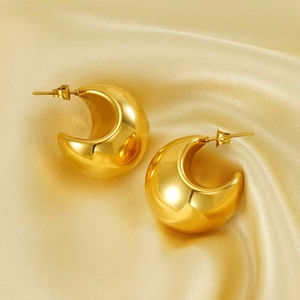 Macro shot of chunky C-shape 18K gold plated stainless steel earrings on gold satin