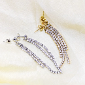 Detailed view of long tassel earrings with double row sparkling cubic zirconia in gold and silver
