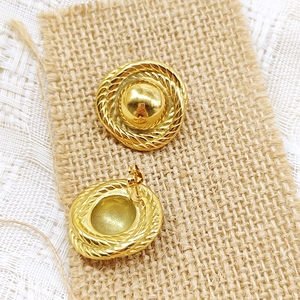 Detail of 18K gold teardrop stud earrings showing the cable texture and ear pin backing