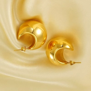 Detailed macro view of 18K gold-plated C-shaped hoop earrings on elegant silk fabric
