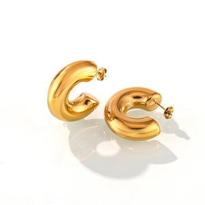 Detailed view of polished 18K gold-plated C-shape thick chunky hoop earrings on white
