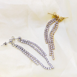 Detail of silver and gold tassel earrings with rows of sparkling zircon stones