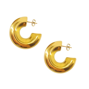 Detailed close-up of chunky gold C-shaped earrings with a polished mirror finish