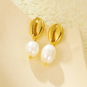 Vue macro de boucles d'oreilles coquillage doré avec perles baroques en goutte