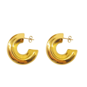 Macro detail of thick 18K gold plated stainless steel C-shaped earrings with polished finish