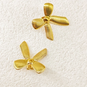 Detailed view of 18k gold plated stainless steel bow earrings with ribbed texture