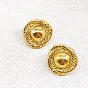 Macro detail of gold 18K plated stainless steel earrings with braided rope edges