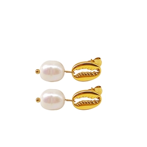 Gros plan sur des boucles d'oreilles coquillage doré avec perles baroques blanches
