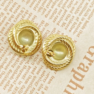 Detailed macro view of vintage 18K gold-plated braided rope texture stud earrings