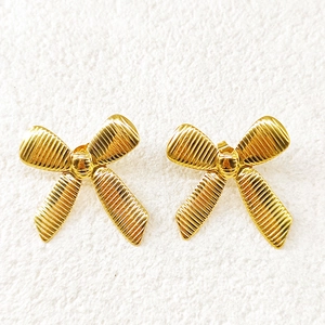 Close-up of 18k gold plated bow earrings featuring detailed horizontal striped textures