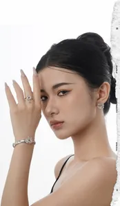 Silver flowery metal jewelry set with ring and bracelet shown on a female model