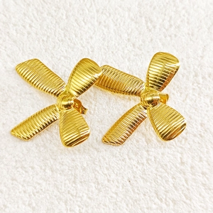 Macro view of 18k gold plated stainless steel bow earrings with ribbed texture detail