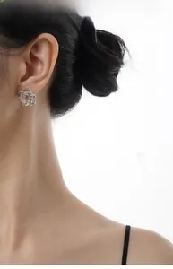 Close-up of S925 silver stud earring with white gemstone on model's ear