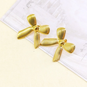 Macro shot of 18k gold plated stainless steel bow earrings with striped texture