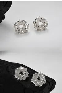 Macro detail of handmade S925 silver stud earrings with thorn design and white stone