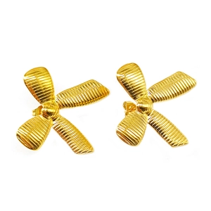 Detailed view of 18k gold plated bowknot stud earrings with textured metallic finish