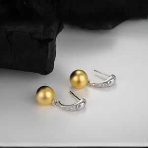 Close-up of matte gold sphere earrings with S925 silver hooks and sparkling zircon detail