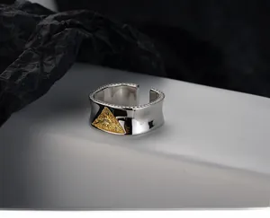 Macro detail of S925 sterling silver ring featuring golden scroll pattern and beaded edges