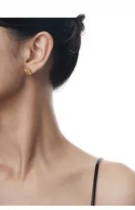 Gros plan d'élégantes boucles d'oreilles lune en or avec cristaux scintillants sur le lobe