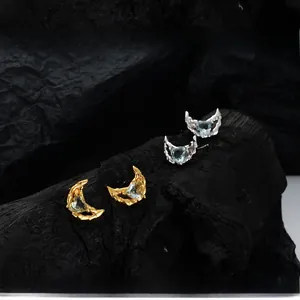 Détails macro des boucles d'oreilles lune S925 en argent avec des pierres bleues