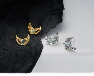 Vue détaillée des boucles d'oreilles lune texture lave avec pierres cœur bleu clair