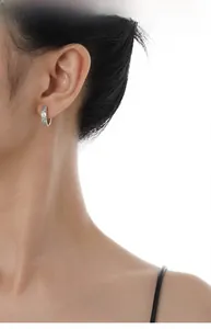 Dettaglio dell'orecchino a cerchio in argento S925 con micro-diamanti sul lobo