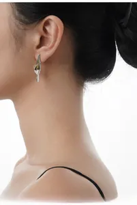 Macro side view of Calla Lily S925 sterling silver earrings with gold stamen detailing