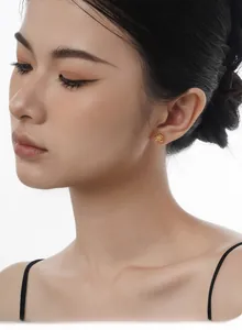 Close-up of golden S925 silver planet stud earrings with white agate inlay on model