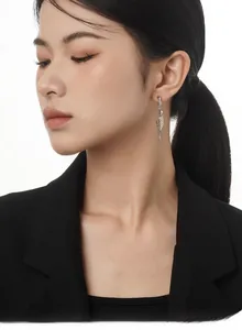 Macro shot of long S925 sterling silver wing earrings with sleek streamlined design
