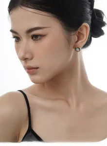Detail of round shell earrings in gold metal setting worn by an Asian model