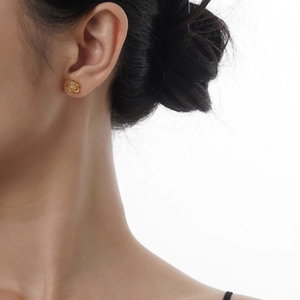 Elegant gold Saturn stud earring featuring white moonstone inlay on a female model