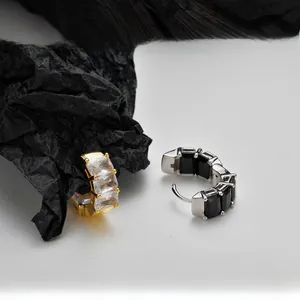 Detailed macro view of S925 silver hoop earrings with square cubic zirconia in gold and black
