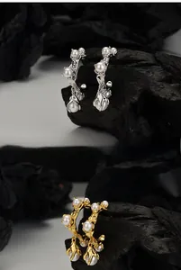 Detail of S925 silver flower earrings with white pearls in gold and silver finishes