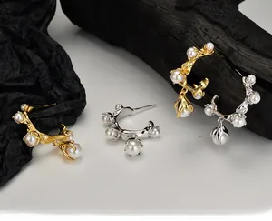 Detailed view of C-shaped pearl hoop earrings in gold and silver with S925 silver studs