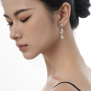 Pendientes largos de plata S925 con diseño de metal texturizado mostrados en una modelo