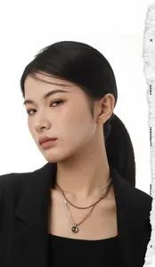 Close-up of a double-layer silver necklace with a round pendant on a model in a suit