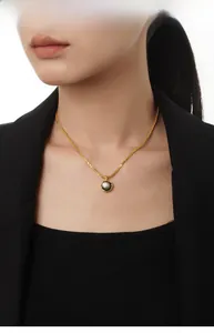 Dettaglio della collana in argento S925 dorato con ciondolo in conchiglia nera su modella