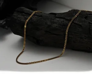Detail view of a vintage gold S925 sterling silver chain on a rustic wood display stand