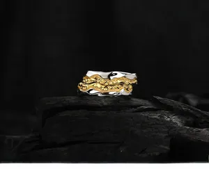 Macro detail of two-tone S925 silver rings with irregular lava texture on dark wood